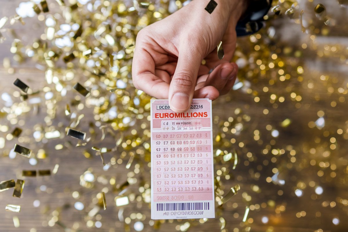 Main tenant un ticket de loterie Euromillions.